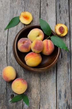 Ahşap arka plan üzerinde Şeftalilerin ahşap kase