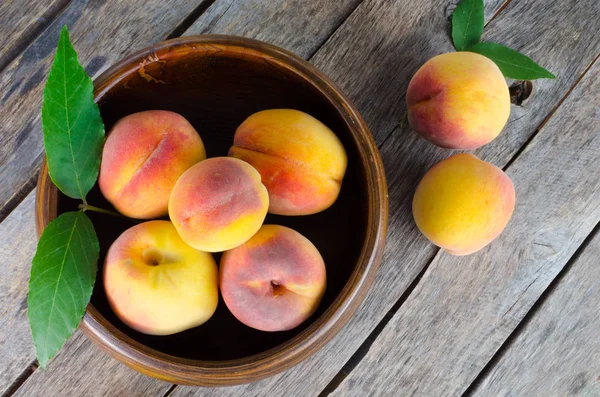 Ahşap arka plan üzerinde Şeftalilerin ahşap kase