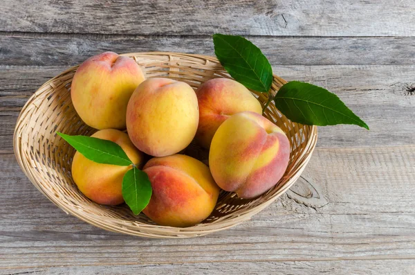 Peaches in a wicker basket — Stock Photo, Image