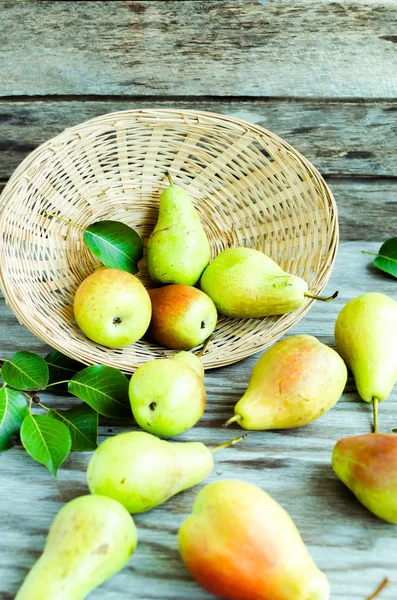 Lot of ripe pears spilled out of a basket — Stock Photo, Image