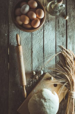 Hamur yoğrulur, kulak buğday, oklava, yumurta ve yağı eski rustik masaya bir şişe