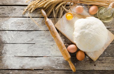 Hamur, oklava ve unlu ahşap arka plan buğday kulaklara