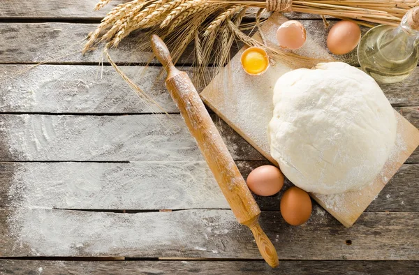 Hamur, oklava ve unlu ahşap arka plan buğday kulaklara