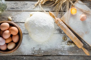 Hamur, oklava ve unlu ahşap arka plan buğday kulaklara