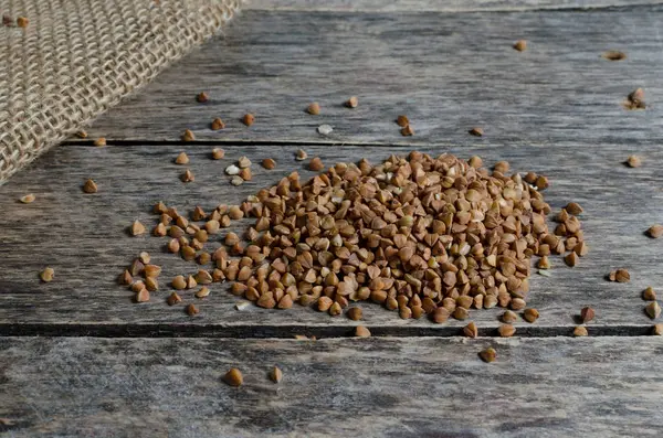 Scatter de trigo sarraceno sobre mesa de madera — Foto de Stock