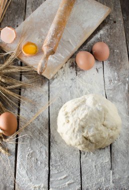 Hamur, oklava ve unlu ahşap arka plan buğday kulaklara