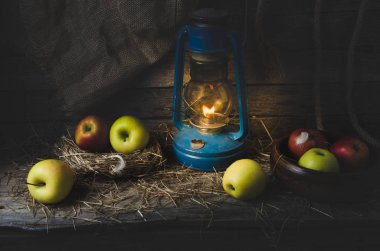 Elma saman içinde bir gaz lambası eski kurulları arka plan üzerinde yaktı.