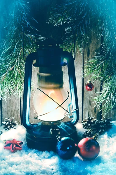 Petroleumlampe auf dem weißen Schneelicht Weihnachtsdekoration und Tannenzweige auf dem Hintergrund — Stockfoto