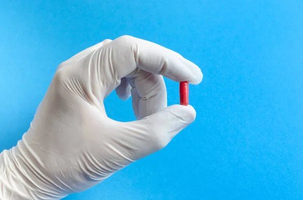 The hand of the medical worker in the medical white gloves holding a tablet