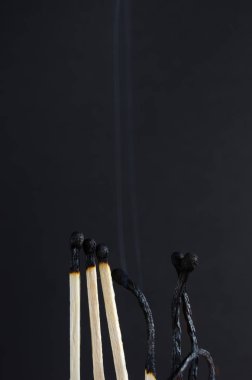 Siyah bir arka plan üzerinde yanmış maçlar