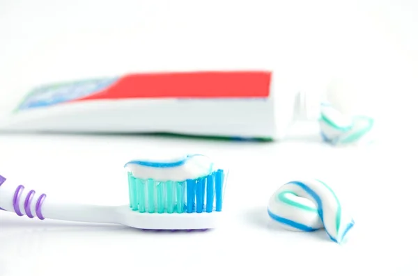 A tube of toothpaste and a toothbrush on white background — Stock Photo, Image