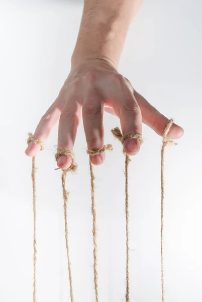 The human hand controls the puppet with the fingers attached to them threads