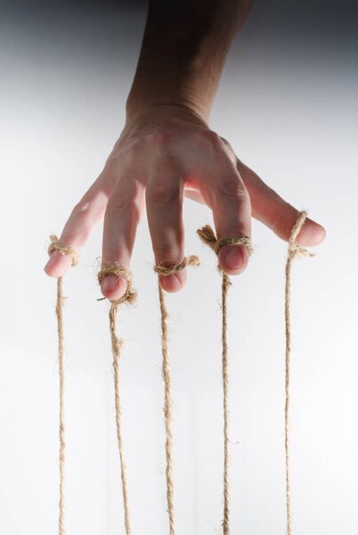 The human hand controls the puppet with the fingers attached to them threads