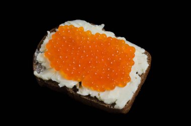 Bir parça siyah ekmek üzerinde kırmızı havyar ve tereyağı sürülür