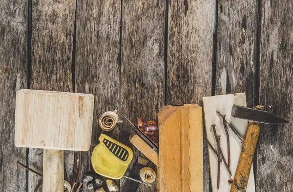 De timmerman tools op houten bankje, vliegtuig, beitel, hamer, meetlint, hamer, Tang, tangen, niveau, nagels en een zaag — Stockfoto