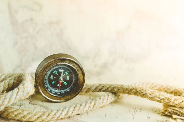 En gammal vintage kompass och ett rep på kartan med en solstråle faller på det — Stockfoto
