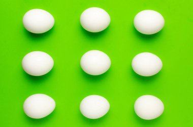 Simetri parlak ışık yeşil zemin üzerine beyaz yumurta.