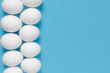 Mavi zemin üzerine beyaz tavuk yumurtası.