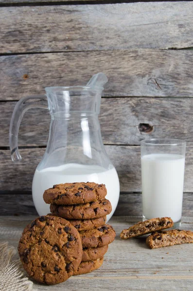 오트밀 초콜릿 칩 쿠키, 용기와 우유, 소박한 나무 배경의 유리. — 스톡 사진
