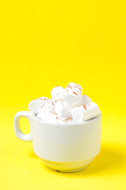 Bir kahve kupa parlak sarı bir arka plan üzerinde beyaz krema.