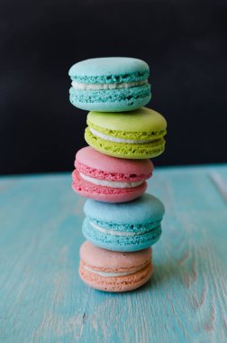 Tanımlama bilgilerini macarons turkuaz ahşap arka plan üzerinde. Şekerli tatlı.