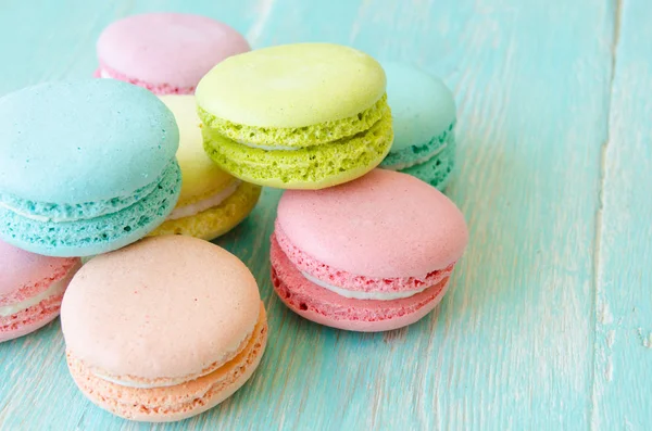 Galletas macarons sobre fondo turquesa de madera.Postre dulce . —  Fotos de Stock