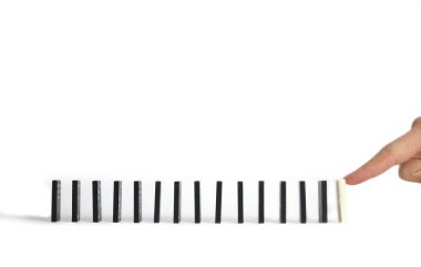 Bir adam beyaz bir Domino 'yu parmağıyla itiyor. Kavram, herkes gibi değil..