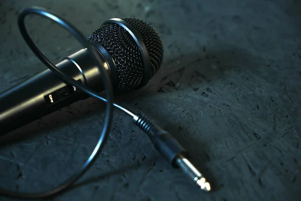 Fekete mikrofon leesett a fekete fapadlóra.Hangszer éneklés és karaoke. — Stock Fotó