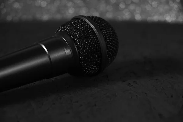 Black microphone dropped to the black wooden floor.Musical instrument for singing and karaoke. — Stock Photo, Image