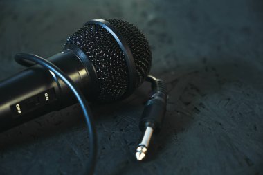 Siyah mikrofon siyah ahşap zemine düştü. Şarkı söylemek ve karaoke yapmak için müzik aleti..
