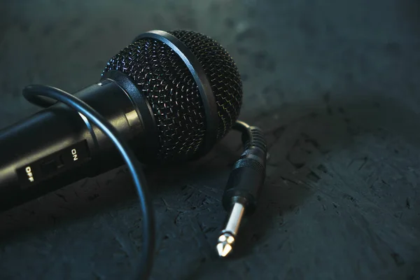 Black microphone dropped to the black wooden floor.Musical instrument for singing and karaoke. — Stock Photo, Image