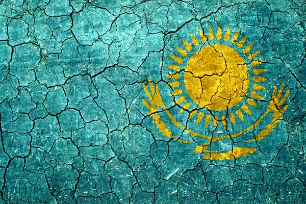 Bilder der Fahne von Kasachstan auf der trockenen rissigen Erde. — Stockfoto