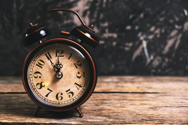 Old retro alarm clock on wooden table. Time is ticking and the h — Stock Photo, Image