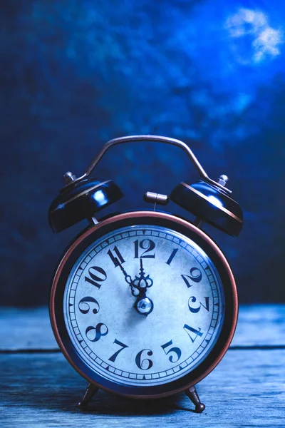 Old, vintage, retro alarm clock on wooden table at night in moonlight. — 스톡 사진