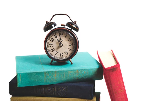 Old, retro alarm clock on a stack of vintage books on a white background. — Stock Photo, Image