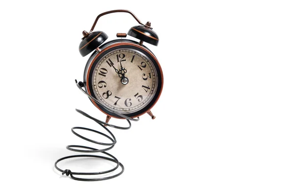Reloj despertador retro vintage rebotando sobre un resorte sobre un fondo blanco . —  Fotos de Stock