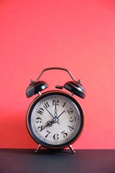 Reloj despertador retro antiguo y vintage sobre un fondo rojo brillante . — Foto de Stock