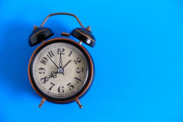 Reloj despertador retro antiguo y vintage sobre un fondo azul brillante . —  Fotos de Stock