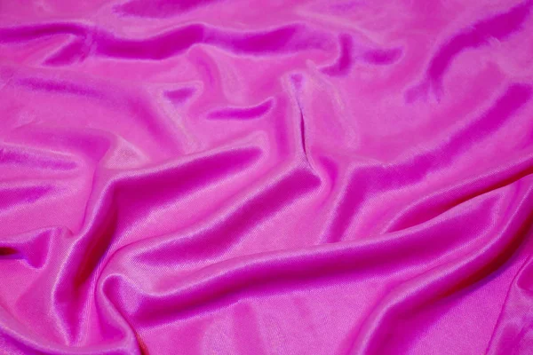 Tekstura, abstrakcyjne tło, jedwabna różowa tkanina artystycznie ułożona. — Zdjęcie stockowe