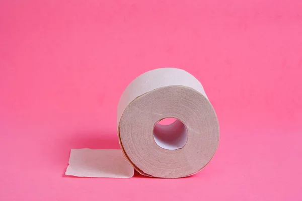 Rolo de papel higiênico em um fundo rosa . — Fotografia de Stock