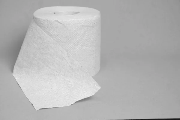 Rollo de papel higiénico sobre un fondo gris . — Foto de Stock