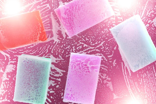 Flerfärgad svamp för diskning på glaset med vätska och skum för diskning. — Stockfoto