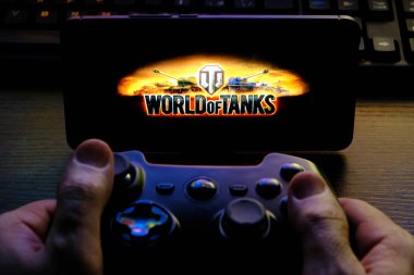 Kostanay, Kazakhstan, February 12, 2020.Joystick and mobile phone with the logo of the popular game World of Tanks, from Wargaming.