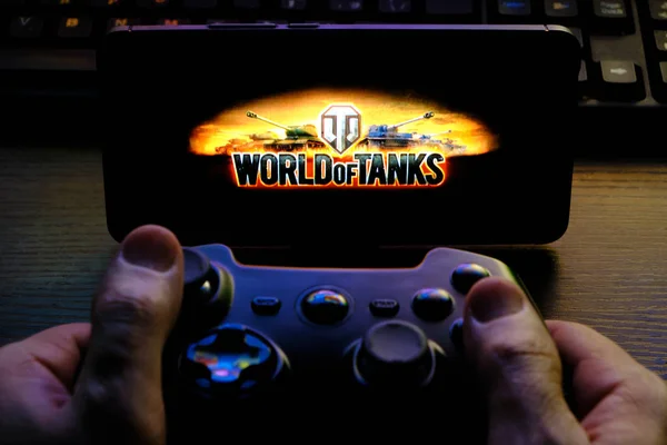 Kostanay, Kazakhstan, February 12, 2020.Joystick and mobile phone with the logo of the popular game World of Tanks, from Wargaming.