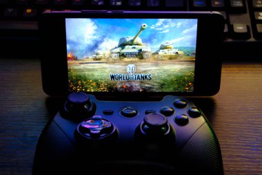 Kostanay, Kazakhstan, February 12, 2020.Joystick and mobile phone with the logo of the popular game World of Tanks, from Wargaming.