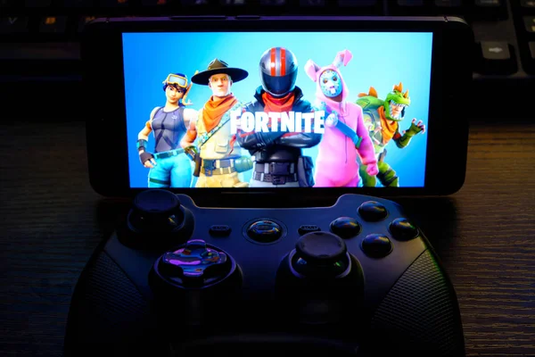 Kostanay, Kazakhstan, February 12, 2020.Joystick and mobile phone with the logo of the popular game fortnite, from Epic Games . — стоковое фото