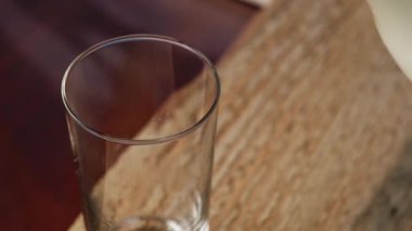 Ev yapımı inek sütü bir testiden bardaklara dökülür. Ahşap bir arka planda..