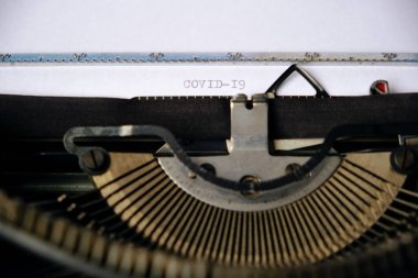 Yazıt COVID-19, eski bir daktiloyla beyaz bir kağıda basılmış.