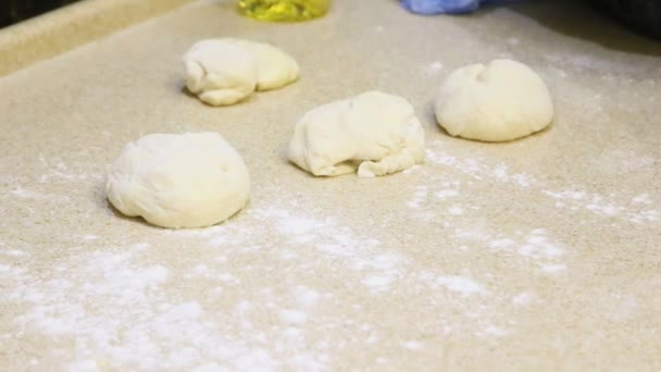 Making dough. Human hands roll out pieces on light table — Stock Video