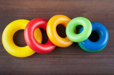 Ahşap arka plan üzerinde renkli plastik halkalar çeşitli